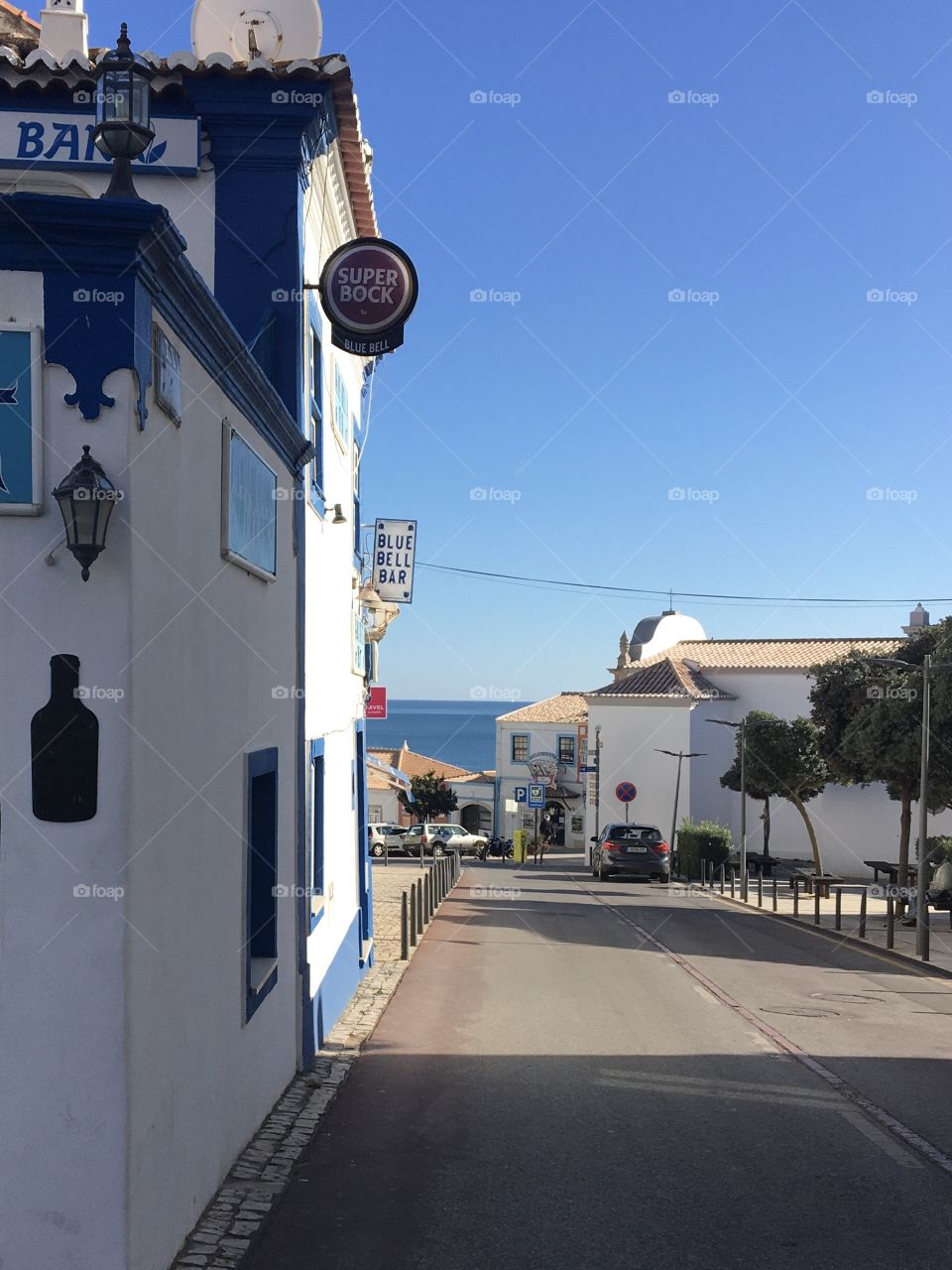 Sun and shadow in a street going to the blue sea
