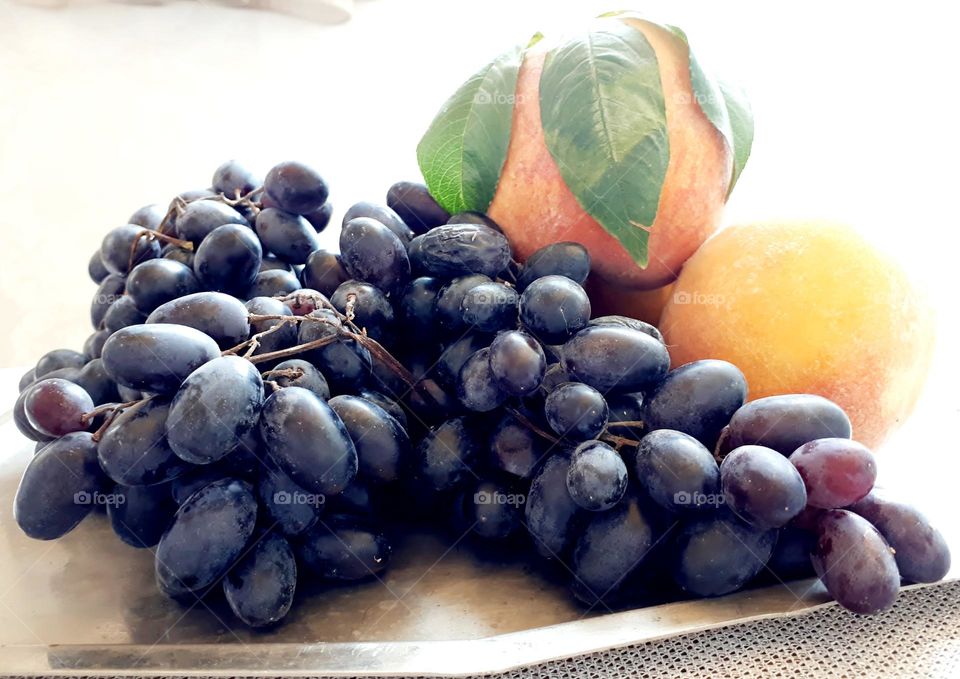 Fruits growing in Armenia, peaches and grapes on the table