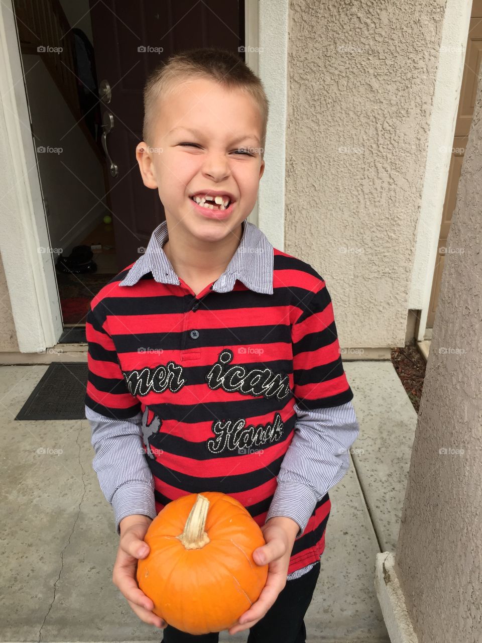 Boy holding small pumpkin 