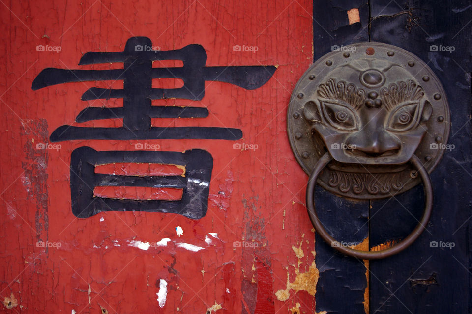 Close-up of door with lion knocker and Chinese word for “book”