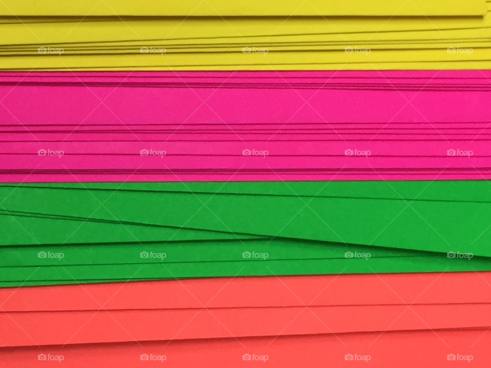 Close-up of a stack of neon colored paper