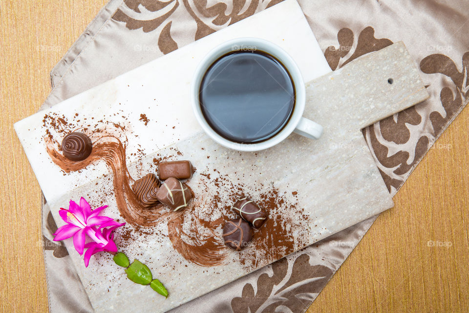 Nothing better than chocolate and coffee together. Sugar eats flat lay with pink flower and cup of coffee