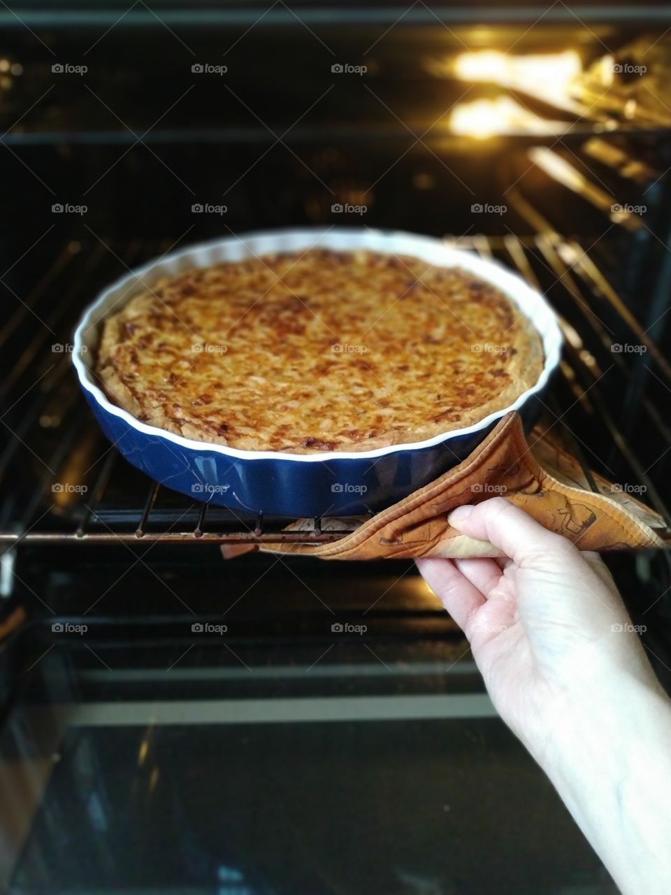 woman takes fish cake out of the oven