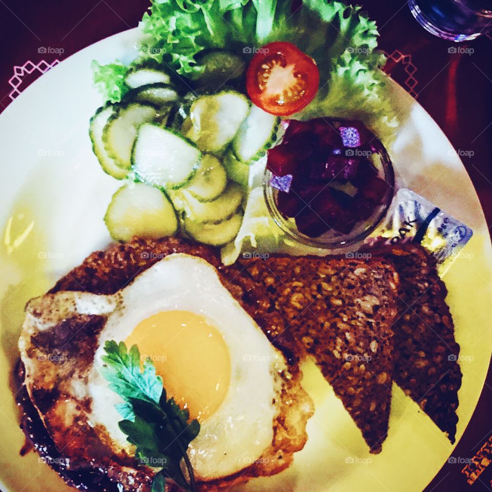 Dish with beef , fried egg and bread