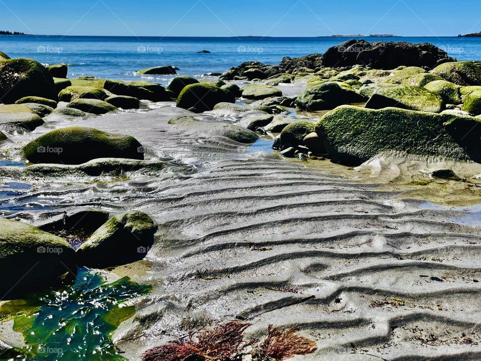 “Tidal Patterns”. Low tide reveals patterns on the sand made by the rhythms of the sea.