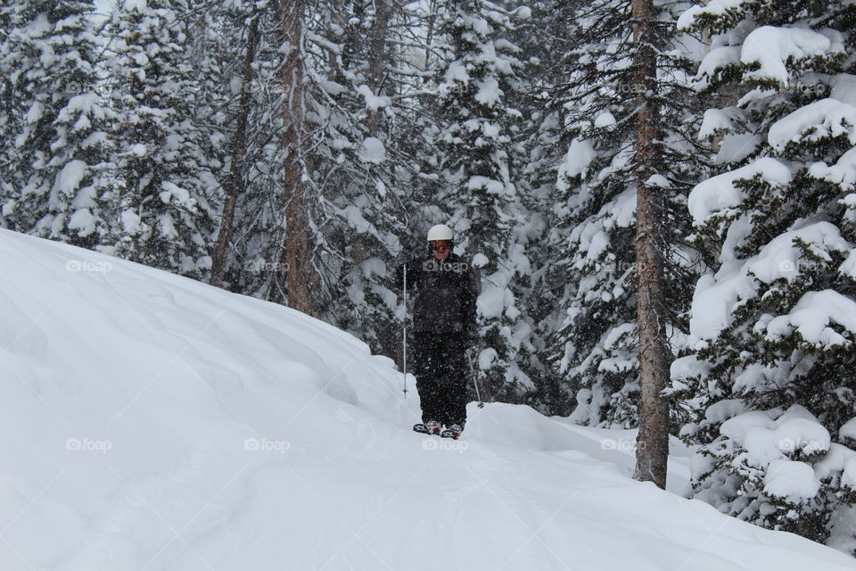 Skier in front of snow covered forest
