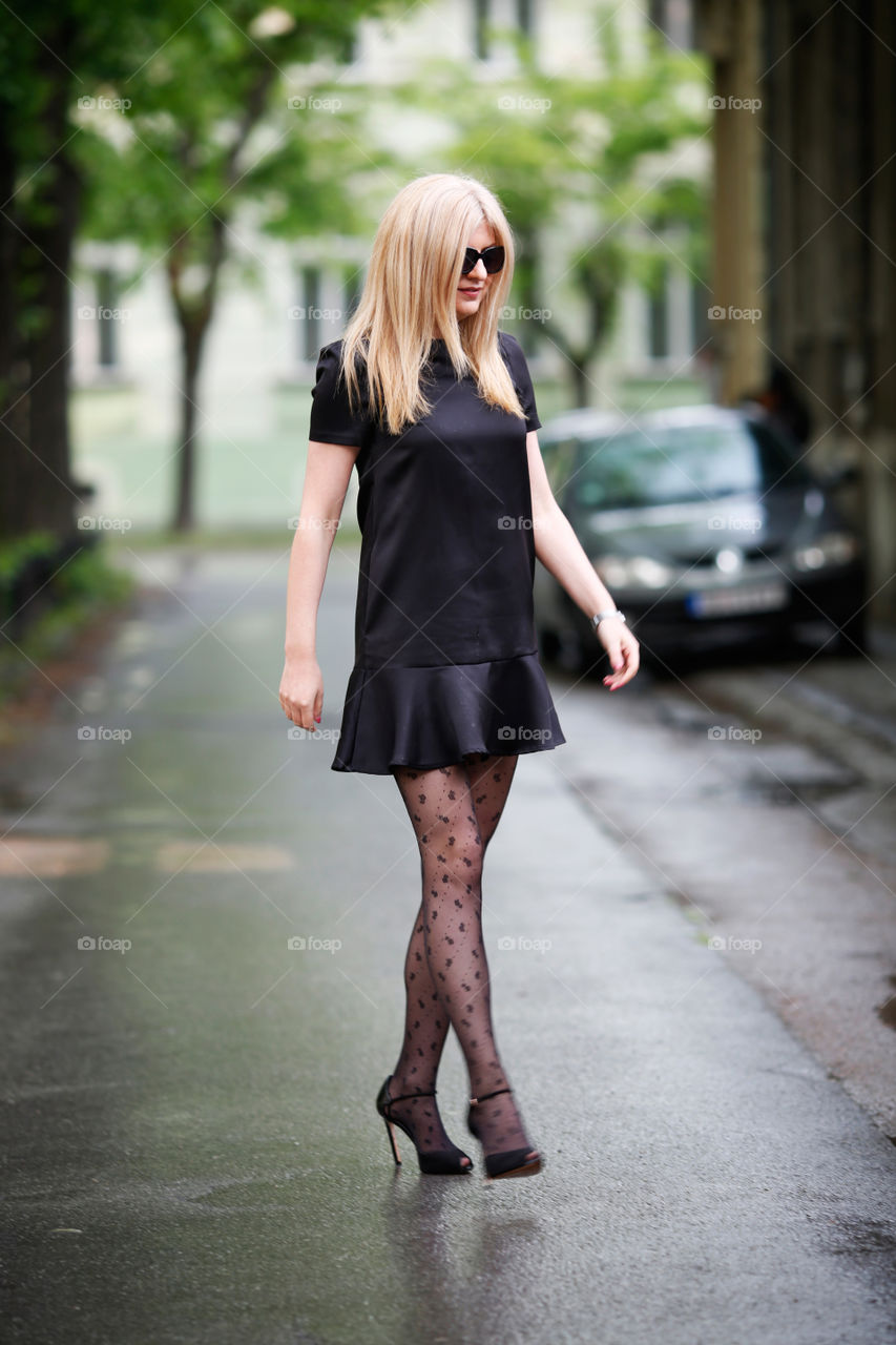 Blonde in black dress crossing the street