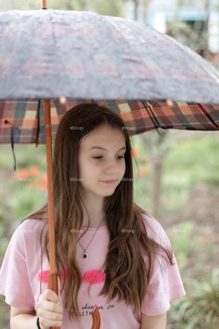 Portrait of pensive teenage girl with umbrella.