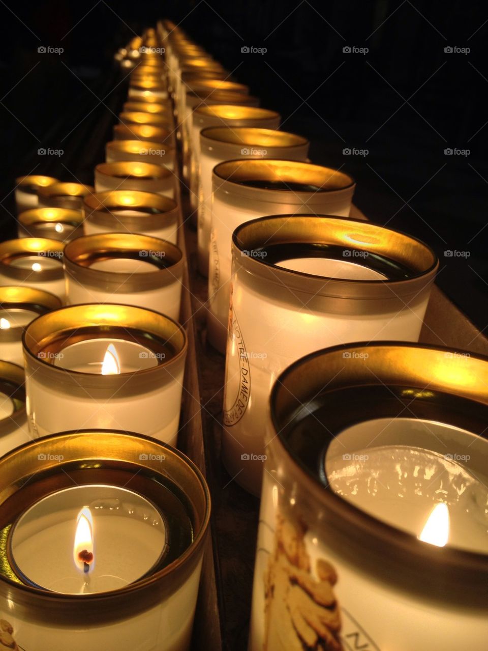 Glowing candles in a row on black background