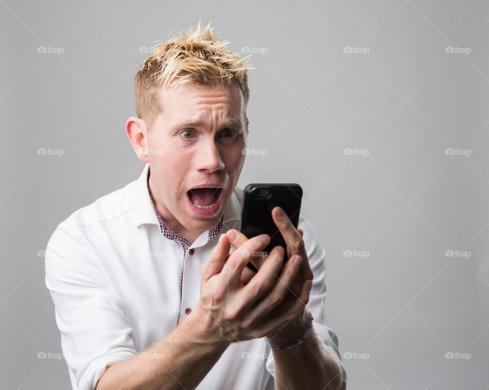 Man with cellular phone surprised.