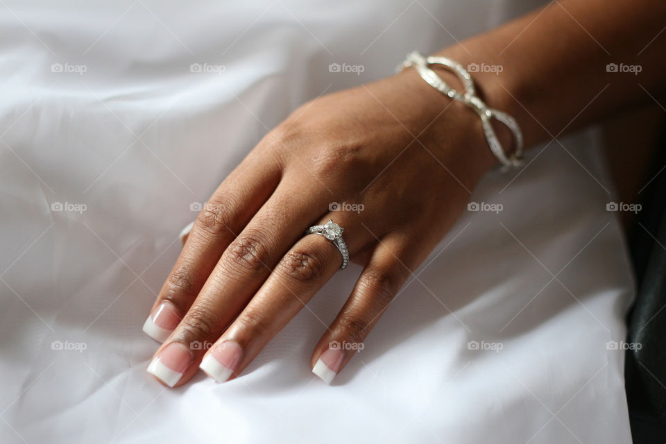 A beautiful wedding ring is on full display as the bride to be rest her hand on her lap.