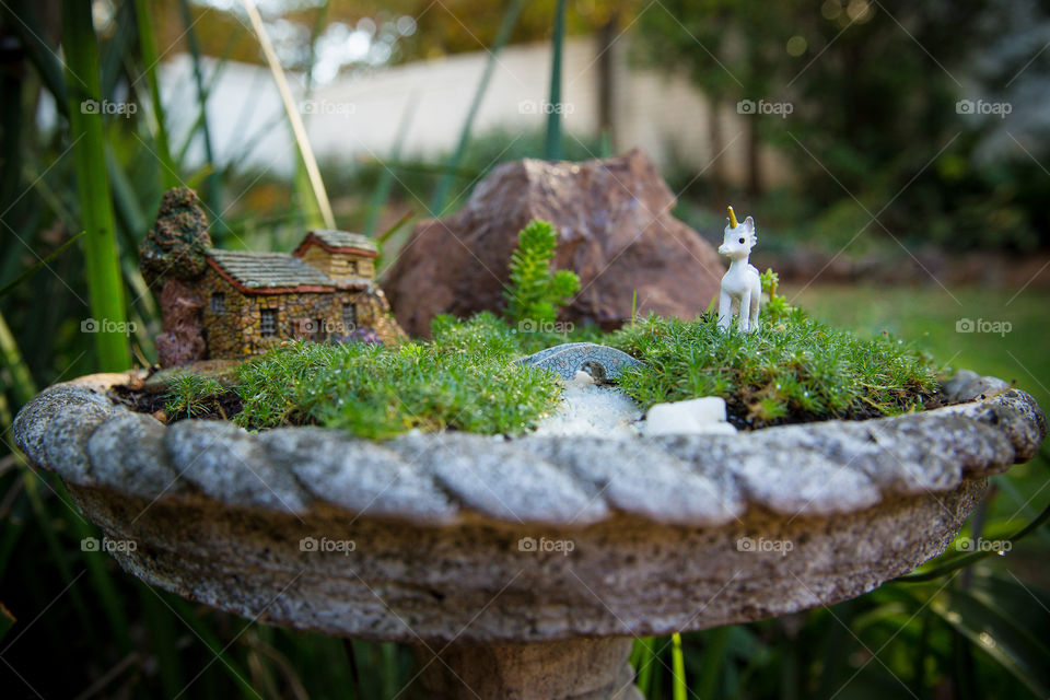 Mini unicorn with stone house garden. oudoor fairy tale garden in old bird bath diy