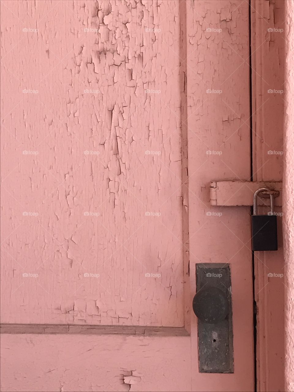 Vintage pink door with peeling paint and old fixtures