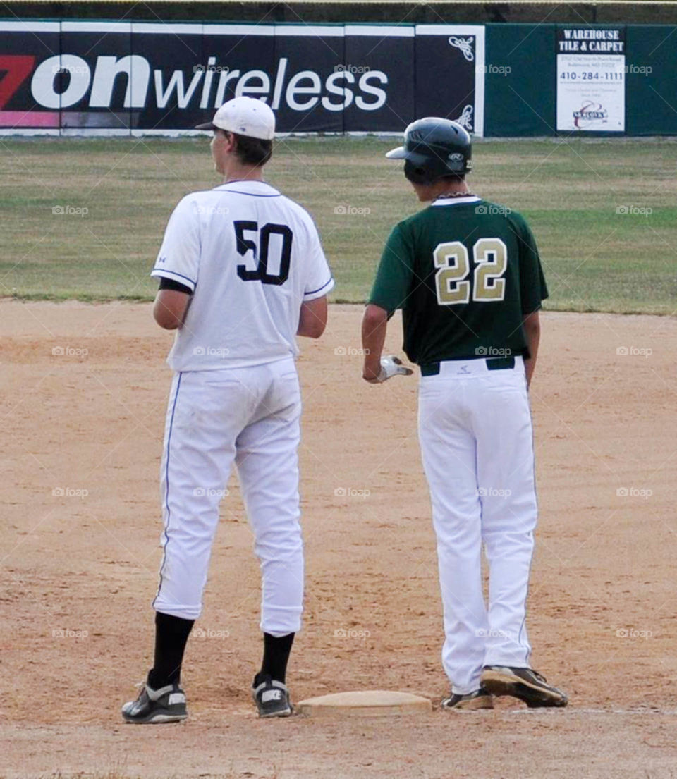 Who's on first?. 6 foot 10 and 6 foot 8 baseball players converse at first base during the game