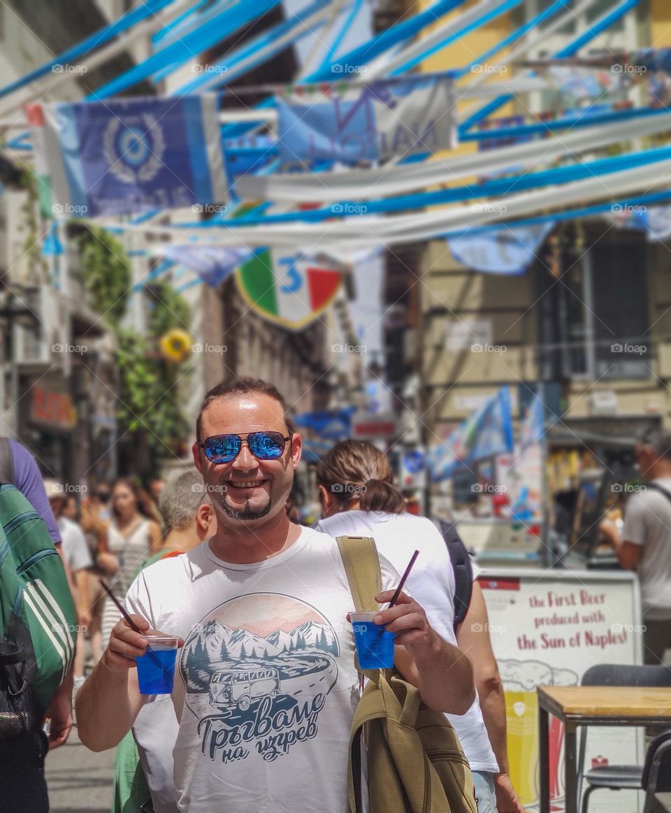 Happy man with blue cocktails on the street