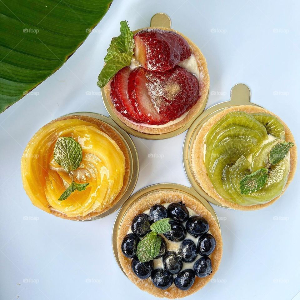 Homemade yummy colourful fruit tarts in berries and kiwi mango