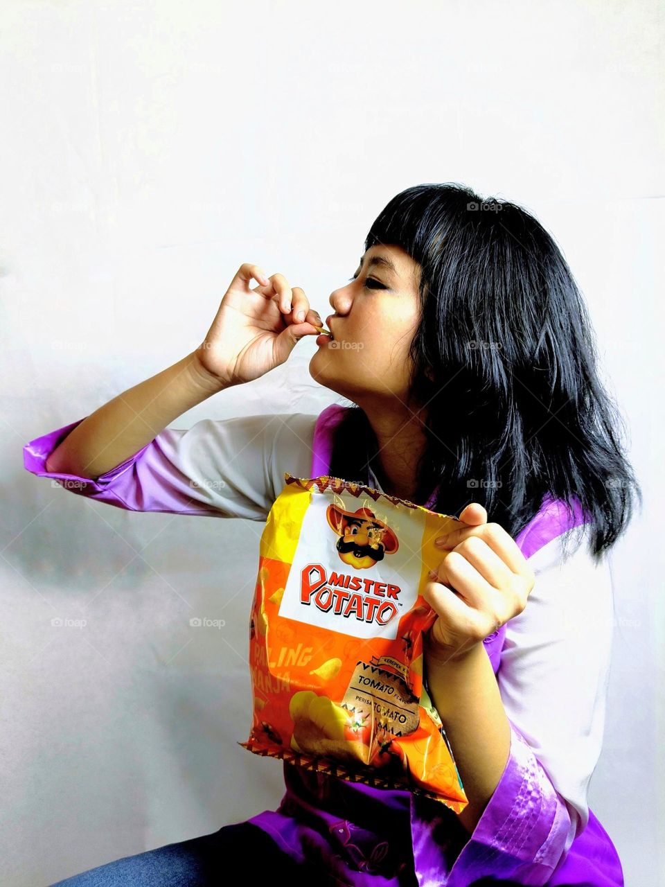 A Chinese girl enjoying to eat the snacks.