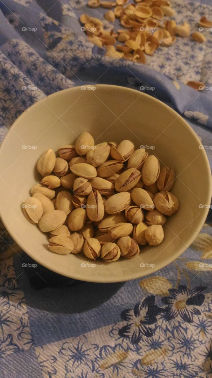 Enjoying eating pistachios while watching a movie