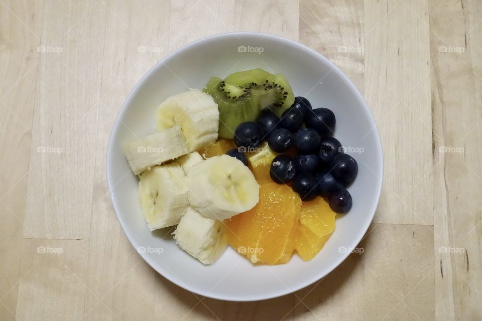 Varieties of fruit : banana, kiwi, blueberries and orange