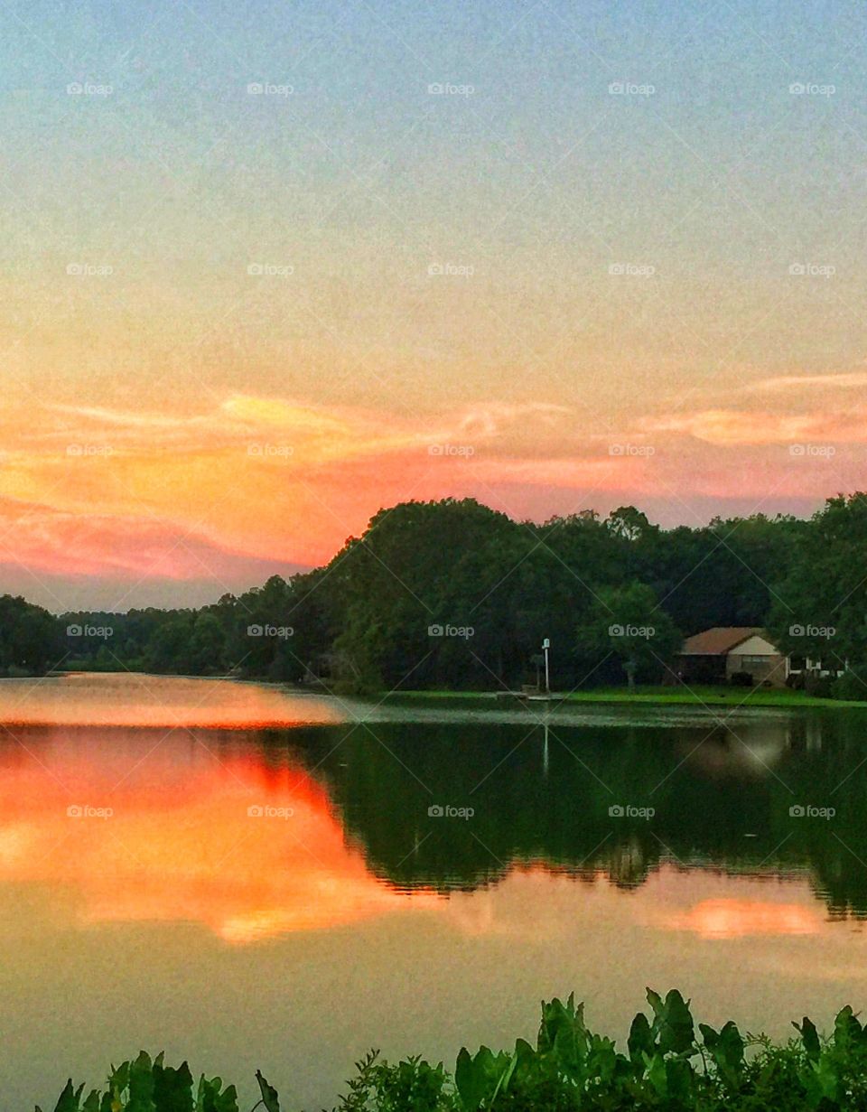 Reflection of trees and dramatic sky on lake