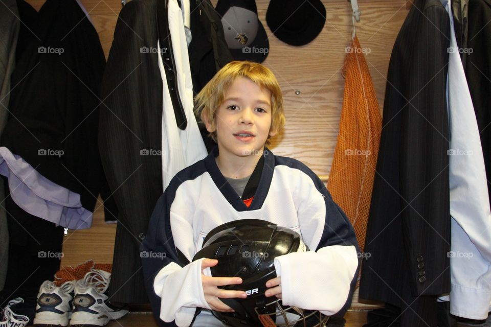 Young hockey player in the professional team's locker room during a hockey game.