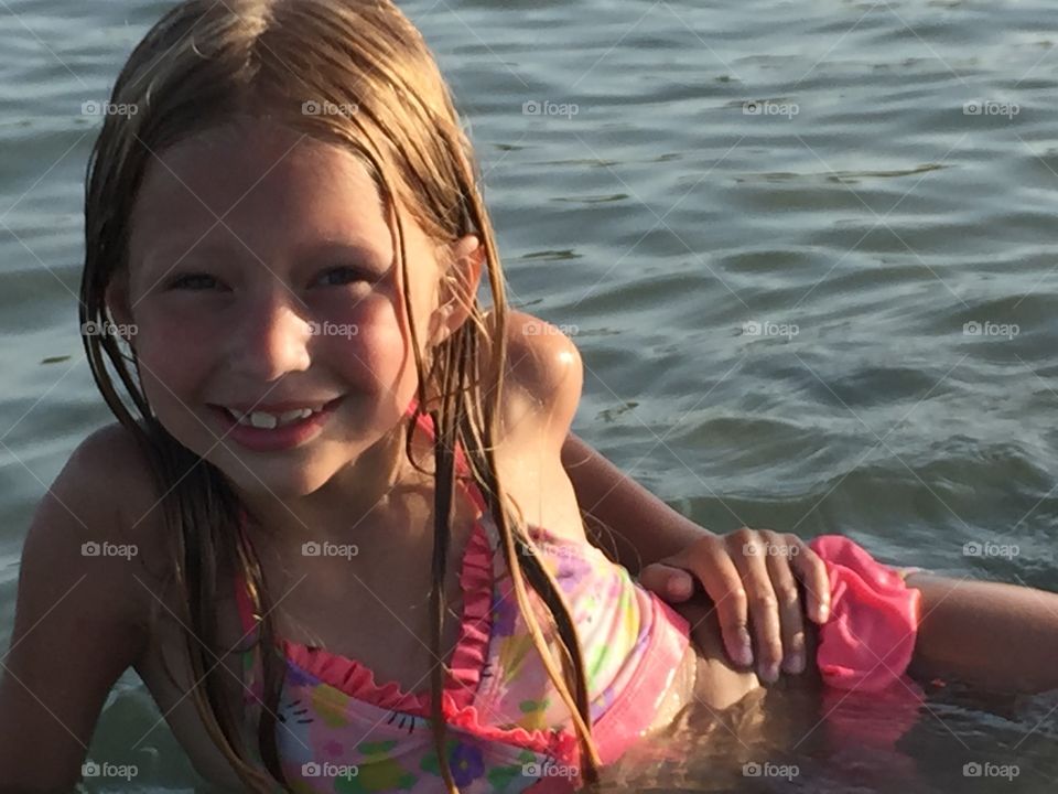 Little girl posing in shallow water of the ocean