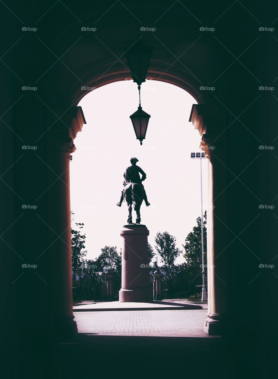 Tunnel made of columns with a view on the sculpture in Saint-Petersburg, Russia