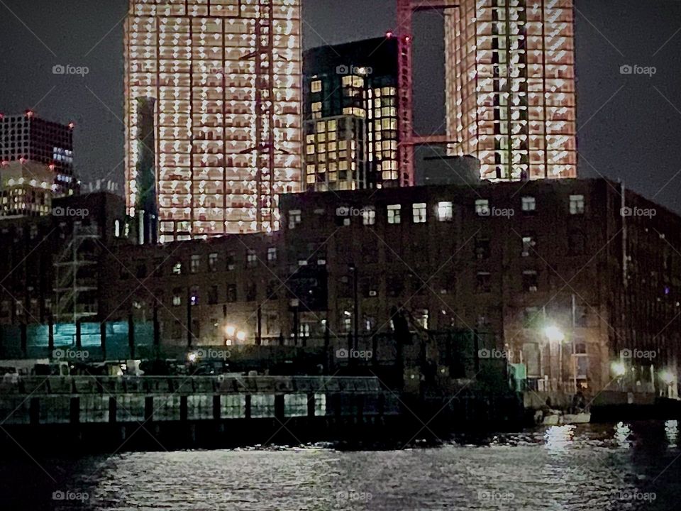 This is „Newtown Creek“ at night where the surrounding high rise buildings cast a beautiful reflection on the water of the „East River“ not to forget the sparkling lights of the electric lighting in the buildings. 2022. Hypnotic Productions