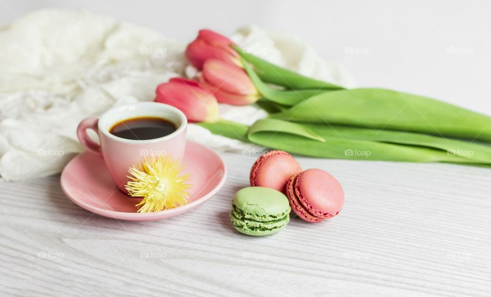 Colourful macaroons with coffee and tulips