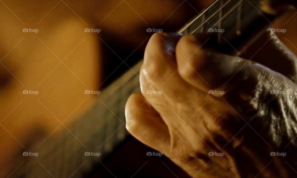 Close-up of a hand playing the guitar