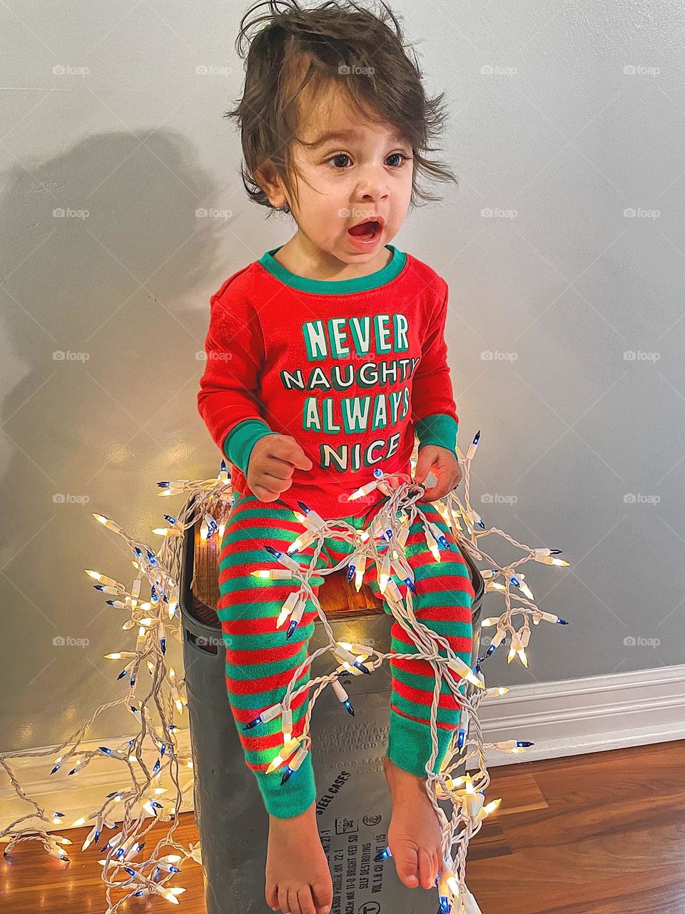 Toddler with Christmas lights showing emotion of surprise, toddler is surprised to see Santa, toddler girl is surprised, toddler girl shows expressions of surprise, facial expressions on a toddler girl, over dramatic toddler, surprised toddler