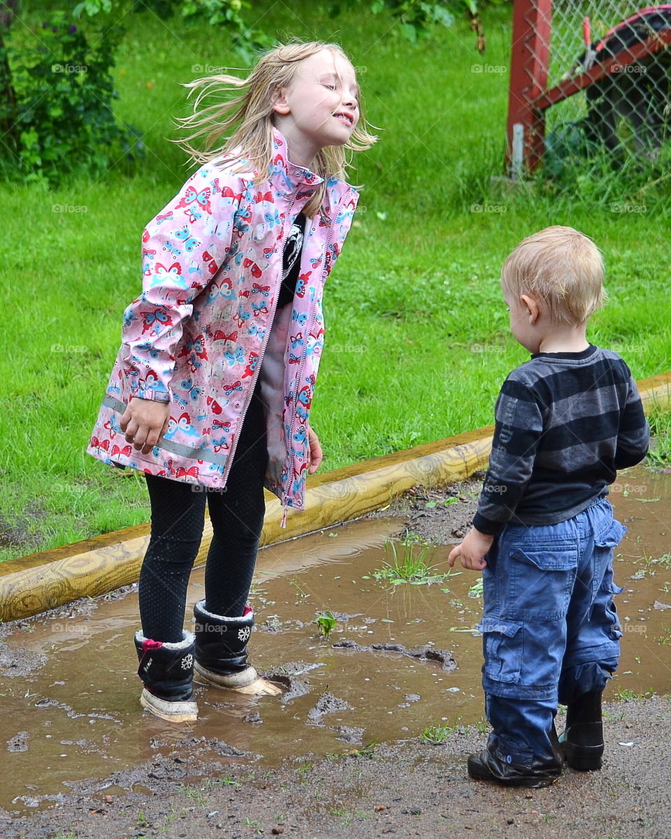 Two children playing in the rain