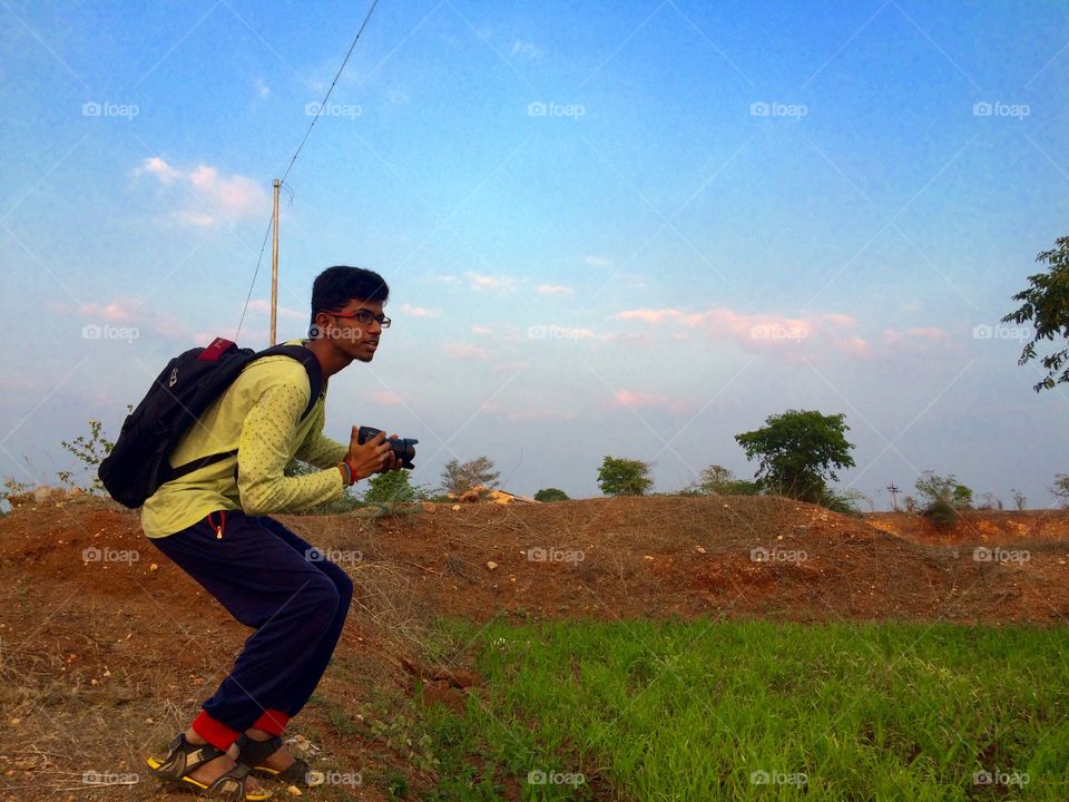 Portrait of boy holding camera in hand