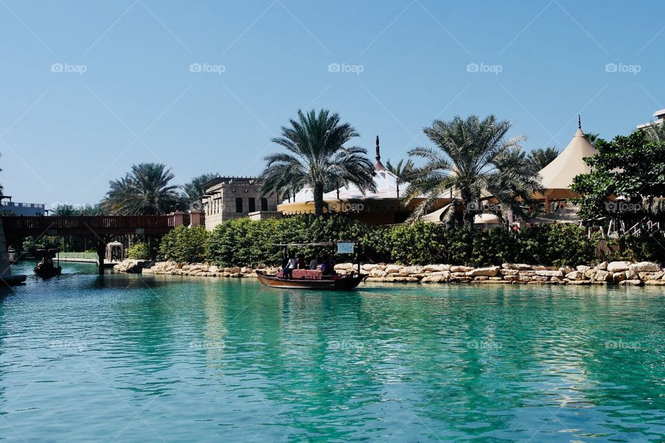 Souk Madinat in Dubai with some palm trees and boat 