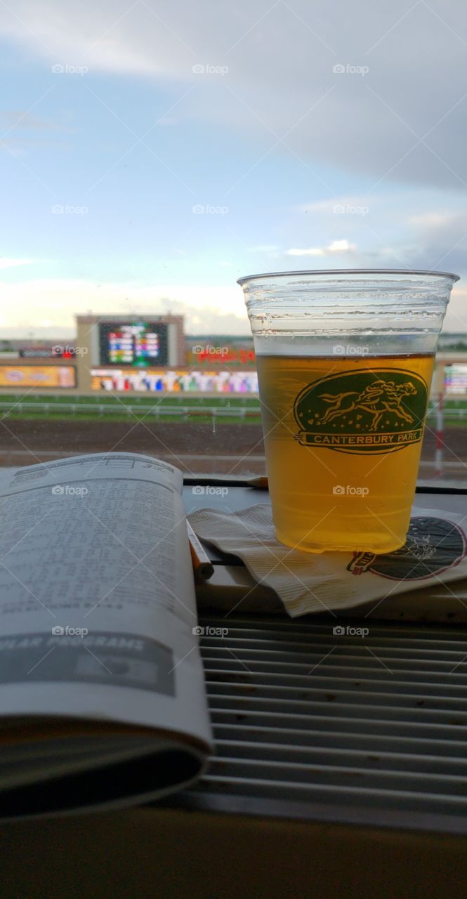 A beer at the horse races in the evening