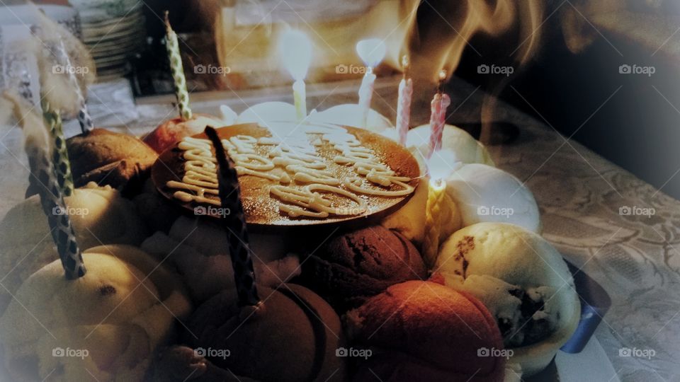 Smoke bellowing up from some extinguished candles on a birthday cake.