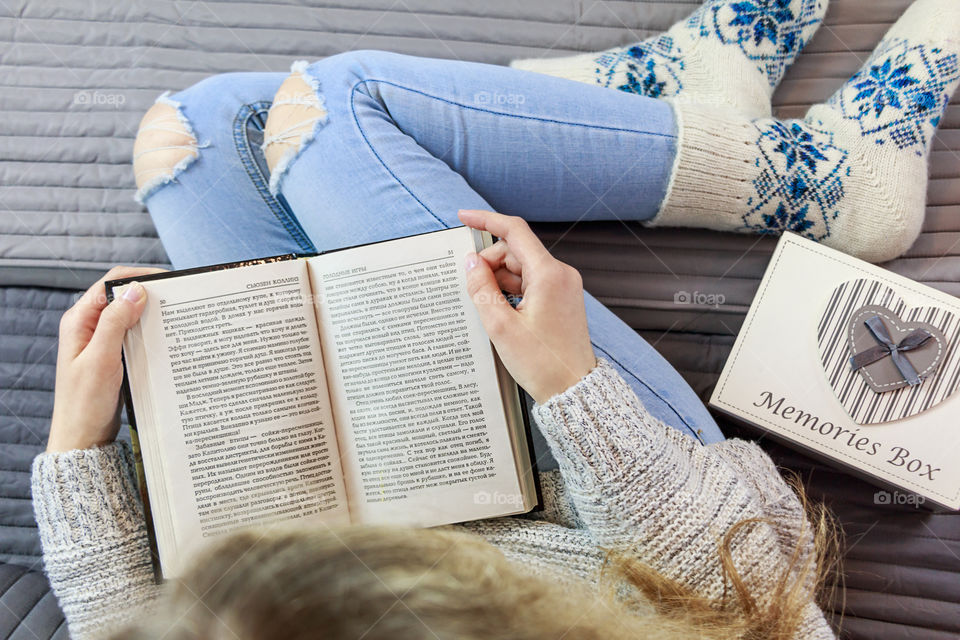 girl sitting on the bed and reading a book