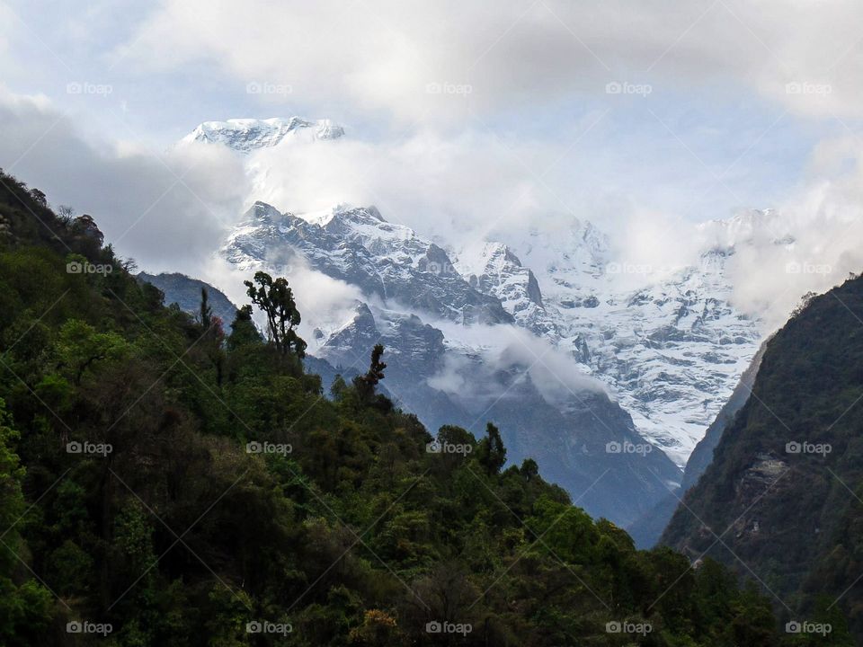 The clouds shroud the distant peaks on approach to Annapurna Base Camp. Photo taken on the Annapurna Base Camp Trek in Nepal.