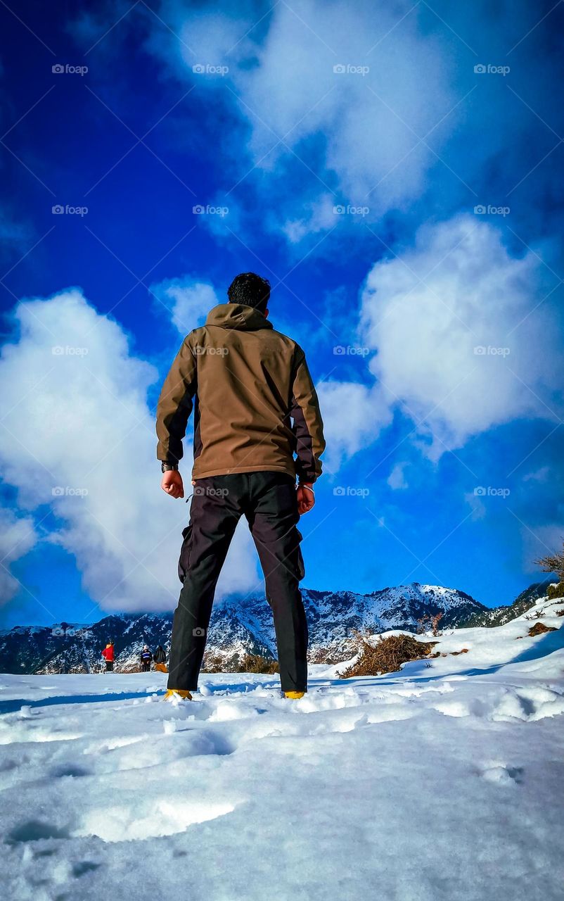 man standing behind beautiful blue sky
