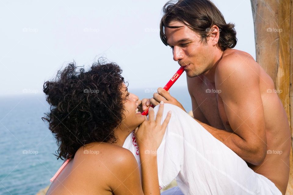 Young man playing the flute to a young woman