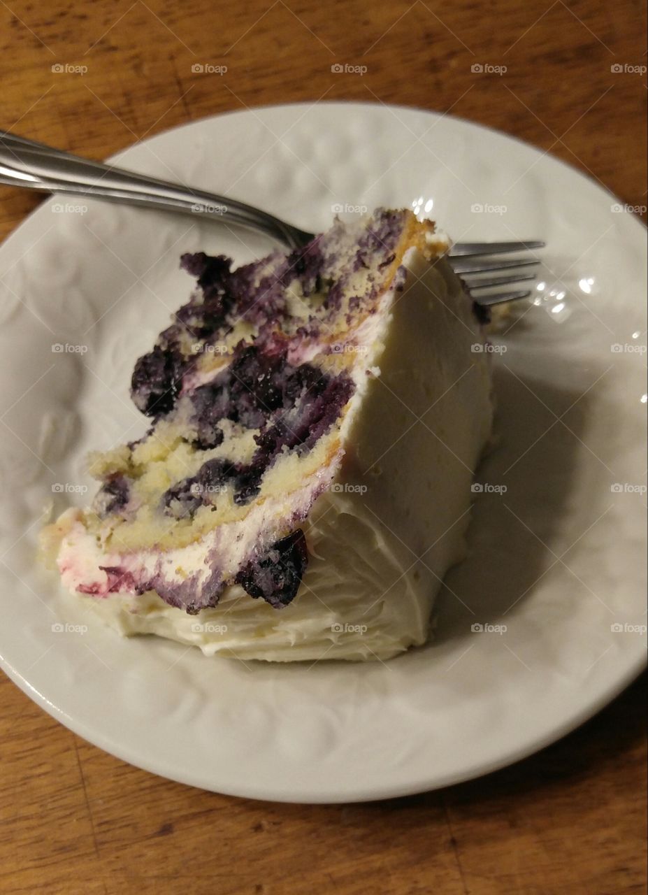 A slice of lemon blueberry cream cheese cake. Up close and delicious.