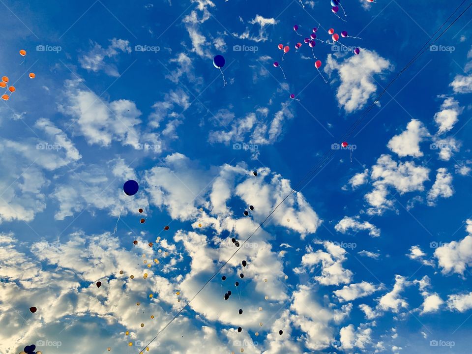 white clouds and colorful balloons high in the sky