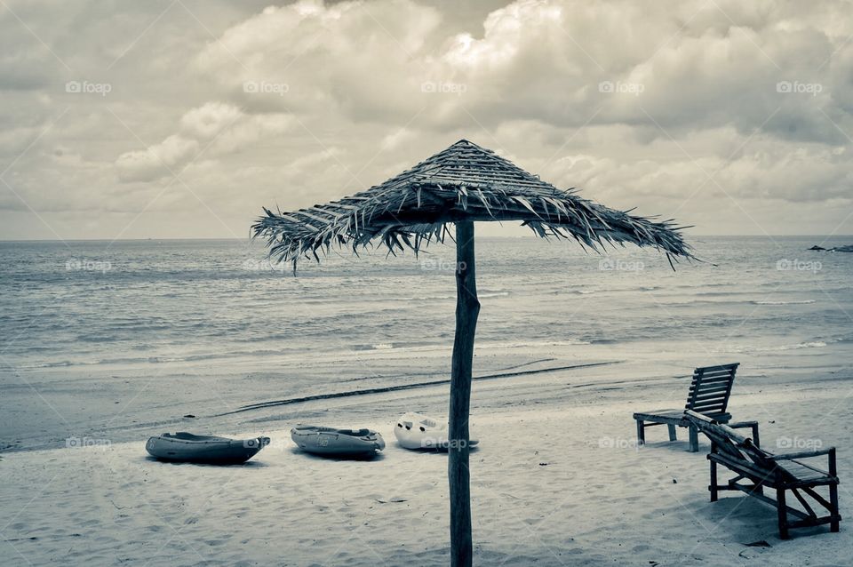 Kayak in the beach . Two chairs. One beach umbrella. 