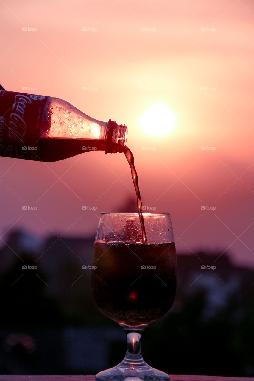 Enjoying the beautiful Evening atmosphere from the balcony above the house with a glass of soda.