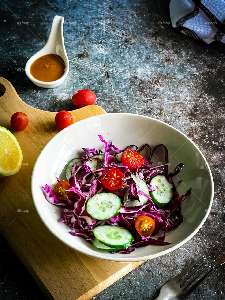 Healthy colourful salad in a bowl and some salad dressing in a small bowl