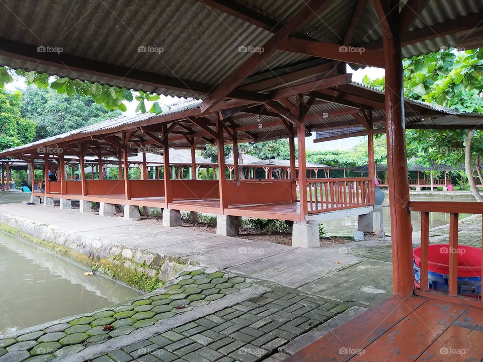 Traditional cafe with wooden gazebo shape in Indonesia is called Saung. Lined with fishing ponds around.