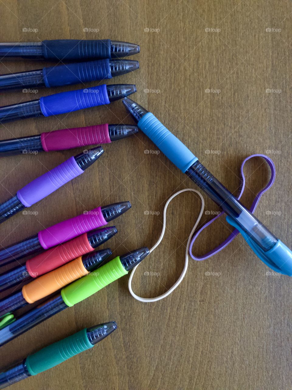 Colorful pens and rubber bands on desk