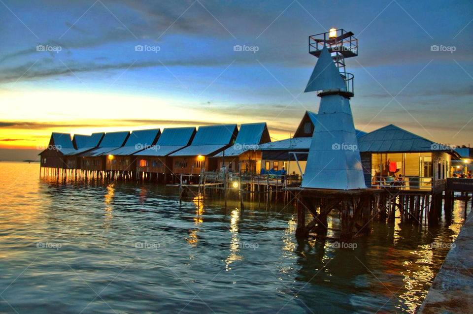 sunset water lighthouse indonesia by sklarian
