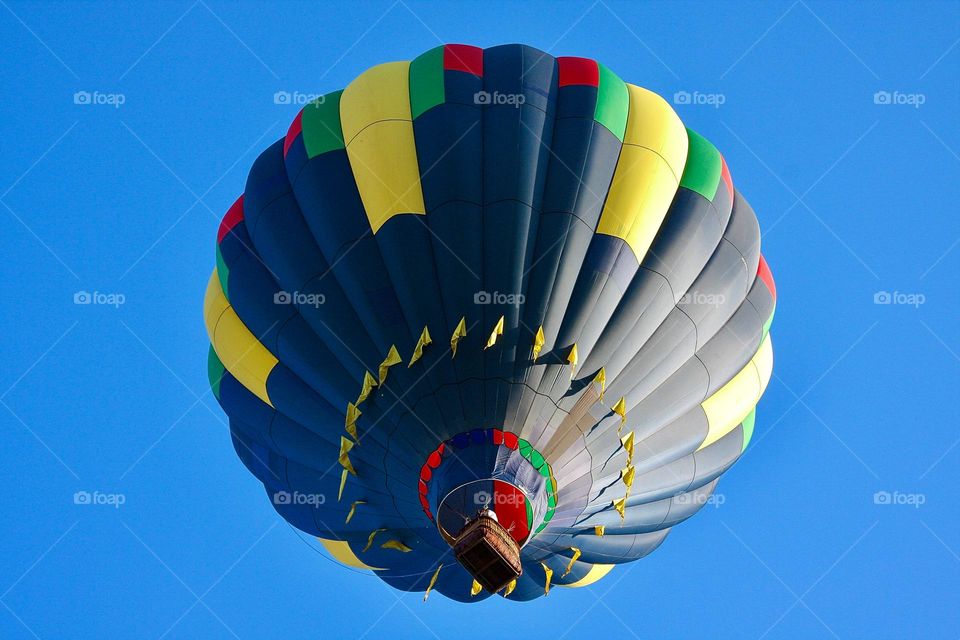 Drifting.  A hot air balloon glides on a wind current as it passes overhead.