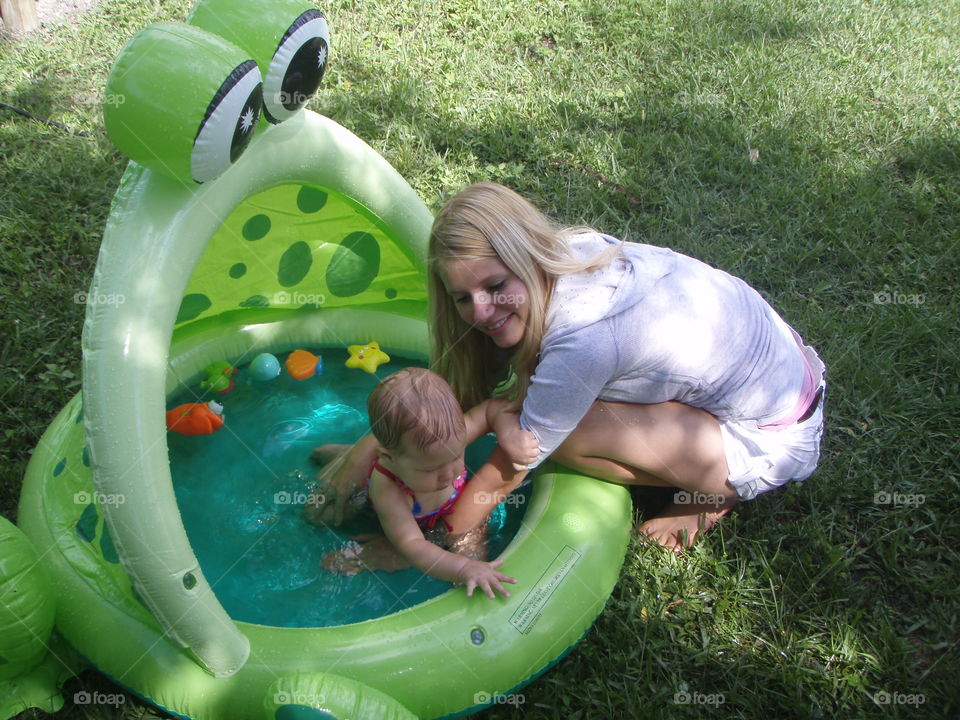 Tina Mom playing with daughter in an infant swimming pool